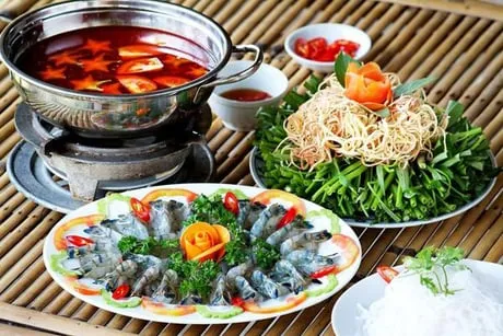 Nồi lẩu chua tôm sú đang sôi, xung quanh là các nguyên liệu tươi ngon