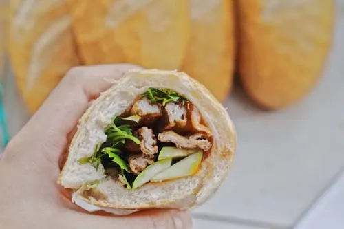 Ổ bánh mì vỏ mỏng giòn kẹp đầy ắp những thanh chả cá nóng hổi cùng các loại rau dưa.