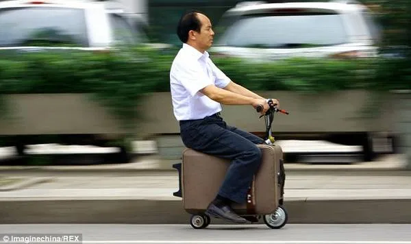 Ông He Liangcai trên chiếc vali tự chế.