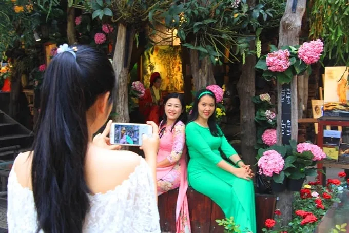 Phụ nữ Huế chụp ảnh trong tà áo dài tại vườn hoa