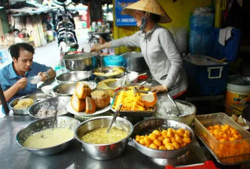 Sạp chè Campuchia hấp dẫn với màu sắc vàng ươm của bí đỏ, bánh trứng, mì trứng, bánh hoa...