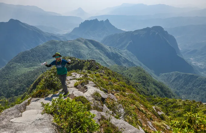Tại đỉnh, trang bị cần có để đi tiếp là đôi găng tay gắn đệm cao su nhằm tăng độ bám cùng giày leo núi. Trong ảnh là một khách leo núi vừa đặt chân đến 