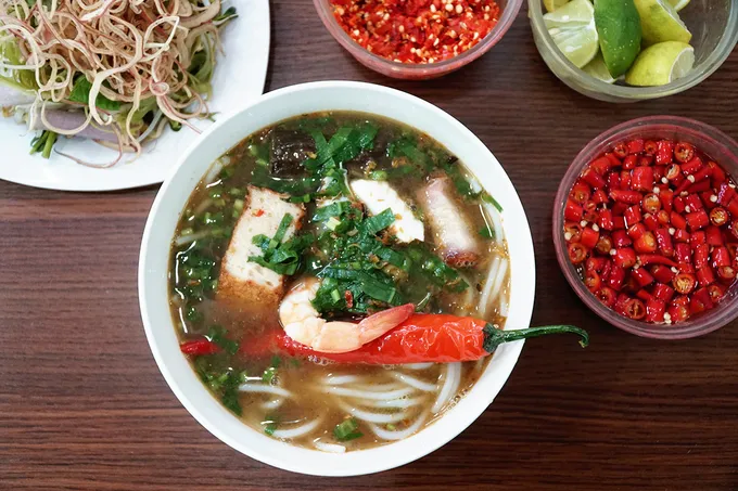 Tô bún mắm đầy đặn với tôm, mực, thịt heo quay, cá lóc, chả cá và ớt dồn chả cá.